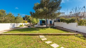 A courtyard with a tree, a pathway, and a building with a blue door. - 3314 Villetta Le Dune Fontanelle by Barbarhouse (Ugento)