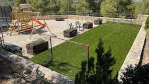 Un espace extérieur clos, doté d’une pelouse, d’aires de jeux en bois et de jardinières.