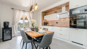 A modern kitchen with white cabinetry, a wooden countertop, and a Bosch oven. - Villa Paula (Privlaka)