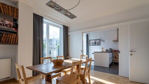 Un apartamento moderno con comedor, cocina y vistas a la ciudad.
