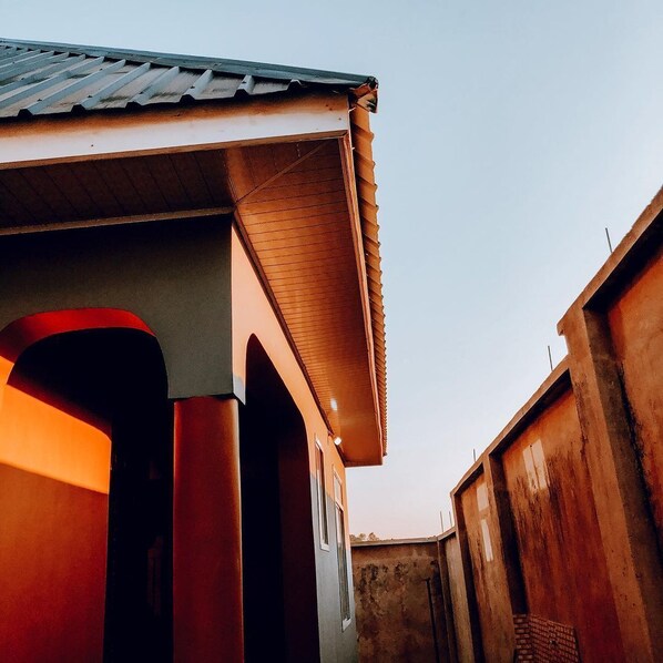 A building with a sloped roof and a visible doorway leading to an interior space.