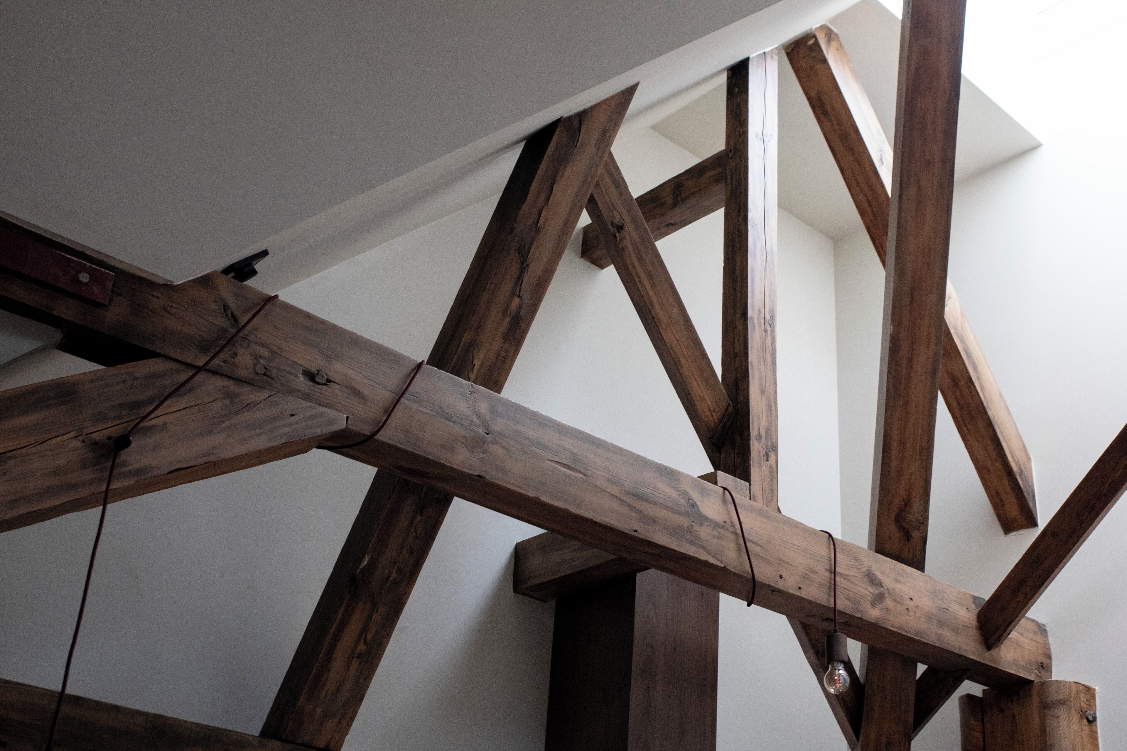 A wooden ceiling structure with exposed beams and a light fixture.