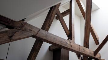 A wooden ceiling structure with exposed beams and a light fixture.