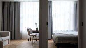 Un dormitorio moderno con cama, una silla y un escritorio.