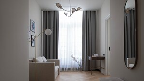 Una sala de estar moderna con un sofá, una lámpara de pie, una mesita auxiliar y un espejo en la pared.