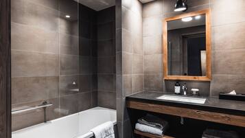 Un baño moderno con bañera, lavamanos y espejo.