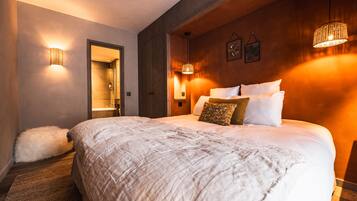 A bedroom with a large bed, a fluffy white rug, and a wooden headboard.