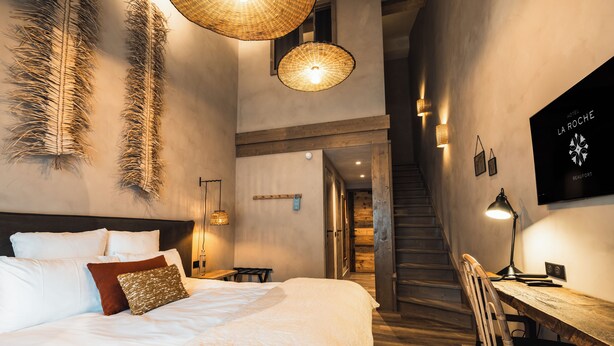 A hotel room with a bed, a desk, and a staircase. - Hotel de la Roche (Beaufort)