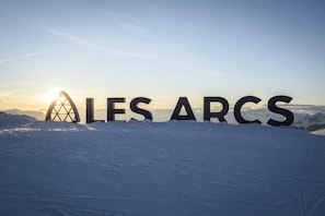 A snow-covered landscape with the words "ALLES ARCS" in large letters. - Chalet Violettes (Villaroger)