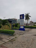 Letrero del Hotel BHC con una palmera y una cerca al fondo.