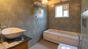 A bathroom with a large white sink, a bathtub, and a towel rack.