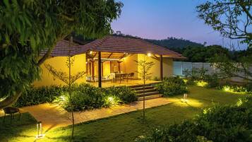 A two-story house with a patio, outdoor seating, and a small pool.