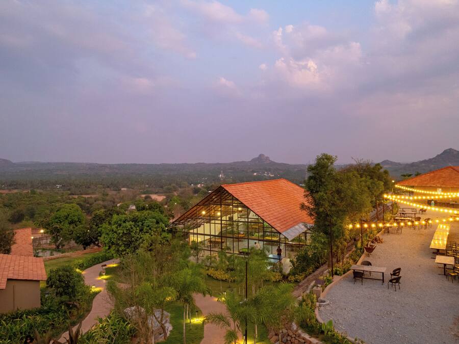A resort with a dining area, outdoor seating, and a view of the surrounding landscape.