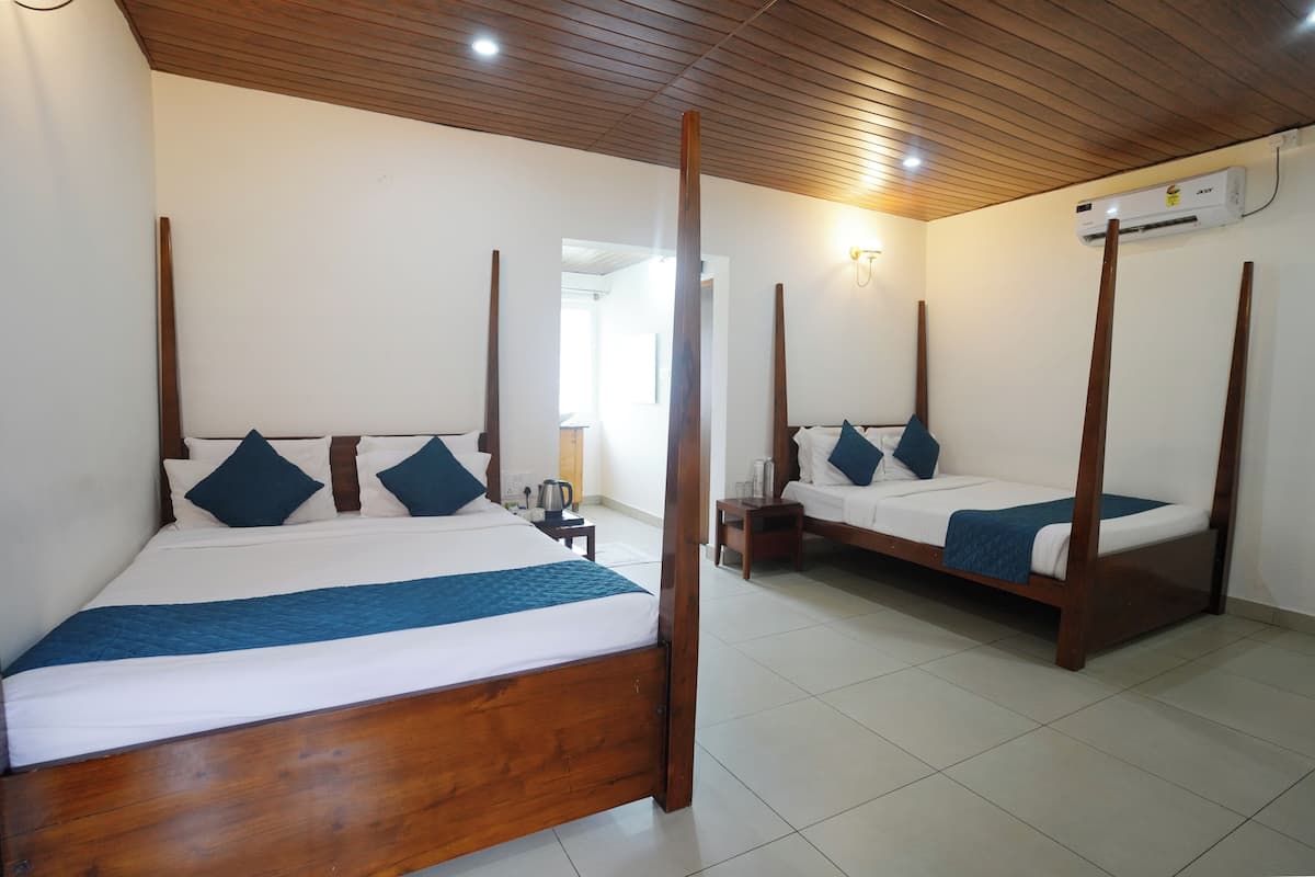 A room with two wooden four-poster beds, white bedding, and a tiled floor.