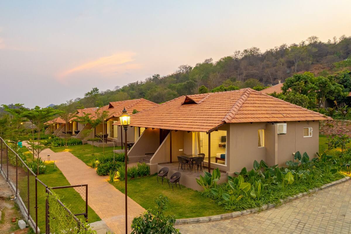 A residential area with houses featuring sloped roofs, a paved pathway, and outdoor seating areas.