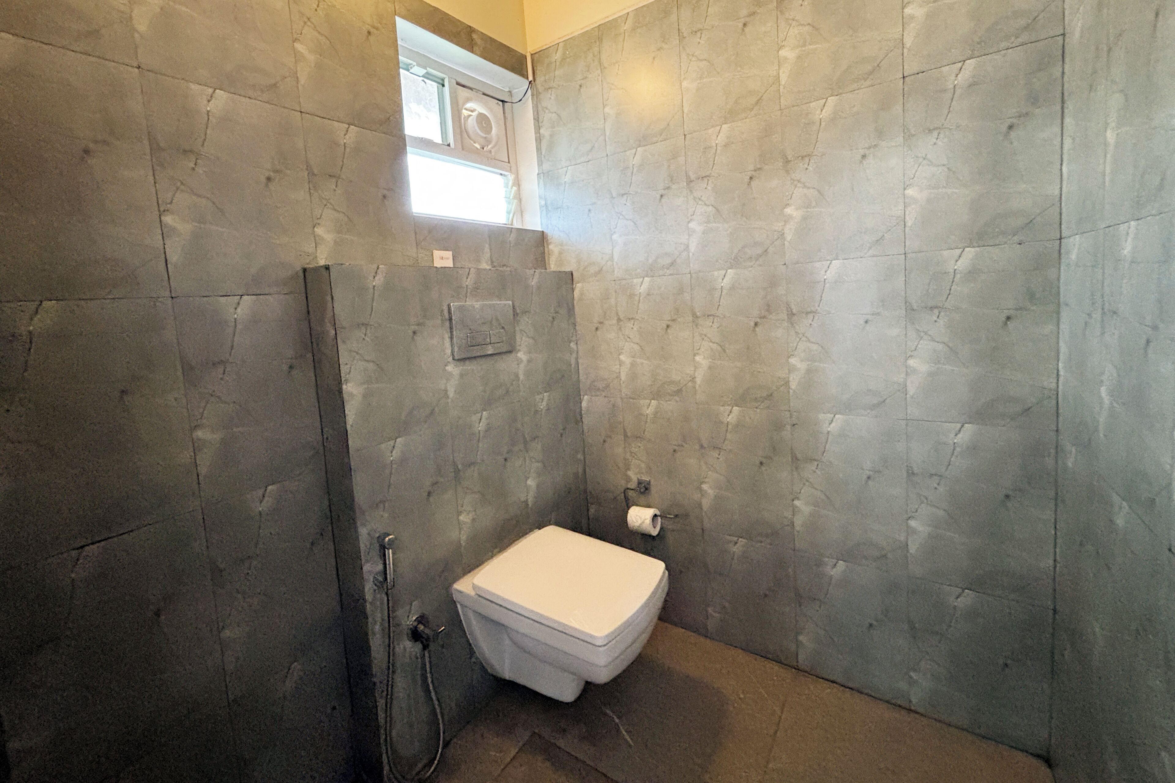 A bathroom with a white toilet, a shower area, and a towel rack.