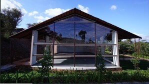 A modern house with a glass facade, a sloped roof, and a stone foundation.