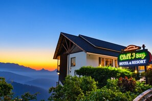 A hotel named 'Chill I Buy' with a sign indicating it's a hotel and resort, surrounded by lush greenery and mountains in the background. - Chill Berg Resort - Bodimettu (Bodinayakanur)
