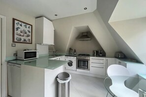 Enjoy cooking in this well-equipped kitchen with microwave, stainless steel oven, and washing machine.