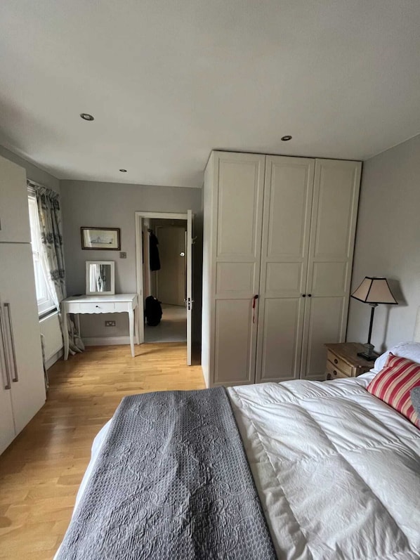 Cozy retreat with a large bed, desk, and wardrobe.