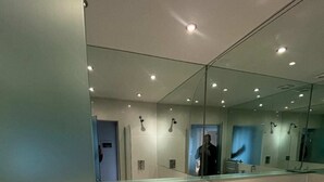 A modern bathroom with a glass shower enclosure, a white bathtub, and a toilet. - Modern Top Floor 2BD Flat - Kensington (London)