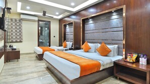 A hotel room with a large bed, two bedside tables, a TV, and a ceiling fan. - Hotel Vanson Delite (New Delhi)