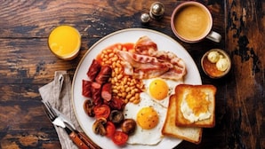 A breakfast plate with eggs, bacon, sausages, beans, tomatoes, and mushrooms. - Hotel Vanson Delite (New Delhi)