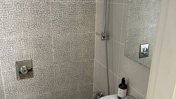 A bathroom with a toilet, sink, and shower.