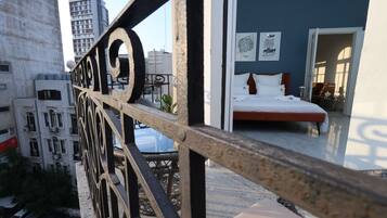 Een balkon met een metalen hekwerk en uitzicht op een stadsbeeld.
