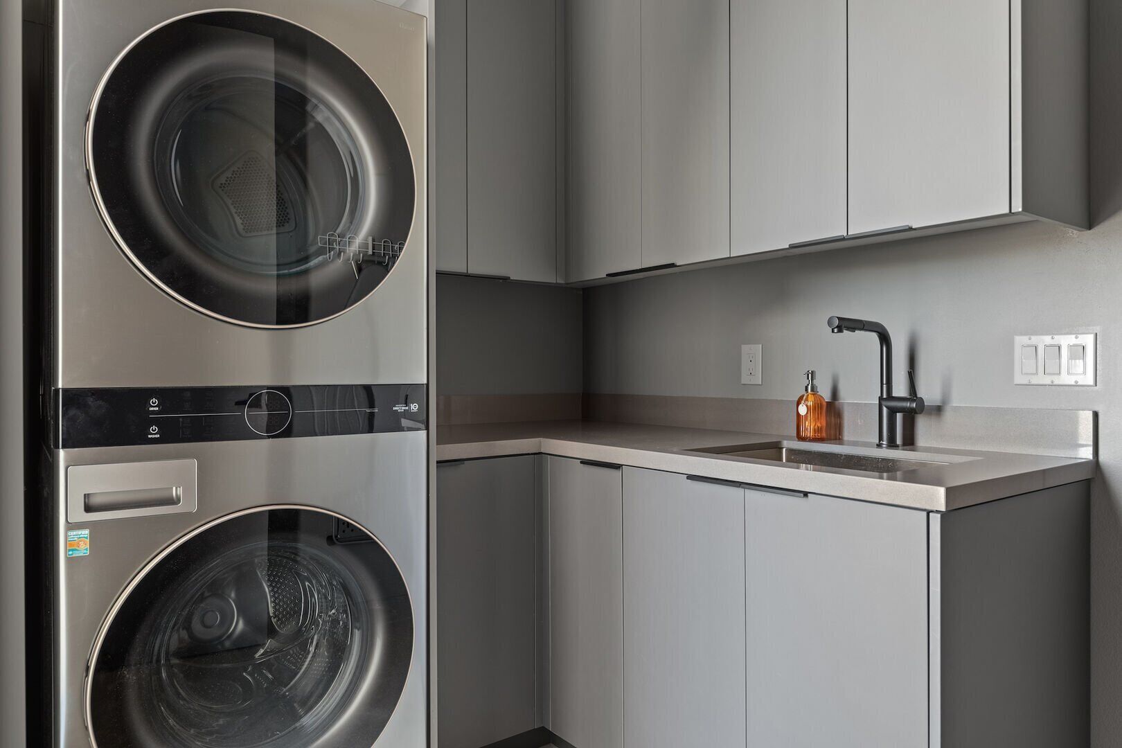 Cozinha moderna com dois eletrodomésticos de aço inoxidável, uma pia e uma torneira.
