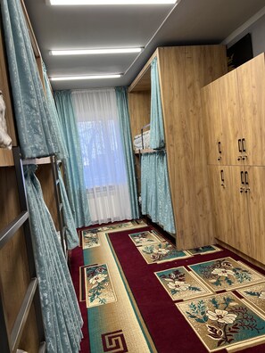 A room with a bunk bed, wooden wardrobe, and a patterned carpet. - Edem Bishkek  (Bishkek)