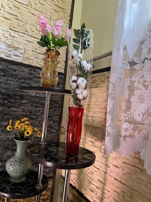 A multi-tiered glass table with vases of flowers and a decorative vase. - Edem Bishkek  (Bishkek)