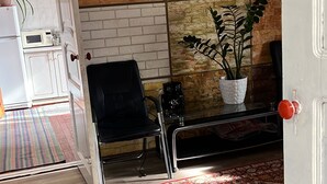 Ein Zimmer mit einem gemusterten Teppich, einem weißen Schrank, einem schwarzen Stuhl und einer Wand mit einem Mosaikfliesenmuster.