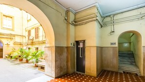An indoor area with a tiled floor, a door with a sign, and a staircase. - Central Station Family Apt by Wonderful Italy (Naples)