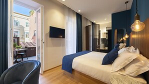 A modern hotel room with a bed, a chair, a TV, and a view of the outside balcony. - Palazzetto Symphony (Rome)