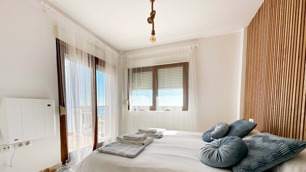 A bedroom with a bed, a window with blinds, a wooden panel wall, and a ceiling light. - STE003 Riverview 4 Bedroom House, with Private Pool (Ayamonte)