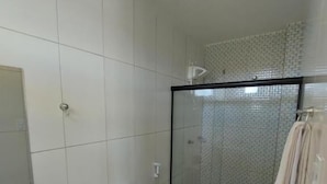 Un baño con inodoro, lavamanos y zona de ducha.
