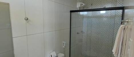 Casa de banho com sanita, lavatório e zona de duche.