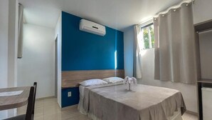 Una habitación de hotel con cama, escritorio y ventana con cortinas.