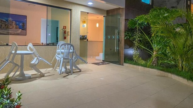 Un vestíbulo de hotel moderno con mostrador de recepción, zona de estar y entrada por puerta de vidrio.