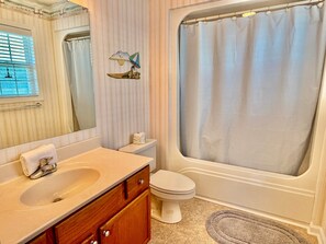 A bathroom with a sink, toilet, and bathtub. - Stay at Reel Estate, a spacious 3-bedroom home in Oak Island, perfect for beach lovers! (Oak Island)