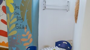 A room with a blue wall, a hat, a table with chairs, and a window with a patterned blind. - Apartment 302 Vista al mar "guest Friendly" (Cartagena de Indias)
