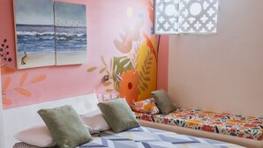 A room with two beds, a window with patterned blinds, and a wall with a floral mural. - Apartment 302 Vista al mar "guest Friendly" (Cartagena de Indias)