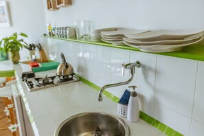 Fridge, coffee/tea maker, cookware/dishes/utensils, dining tables