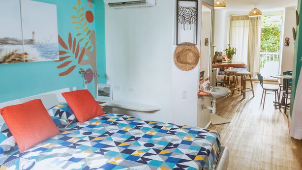 Une chambre avec un lit, une salle de bain et un coin repas.
