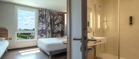 Una habitación de hotel moderna con cama, ducha y ventana con vistas.
