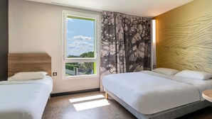 A hotel room with two beds, a large window with a view, and a modern wall design.