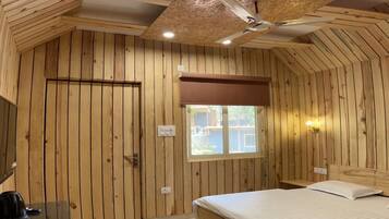 Una habitación con paneles de madera, una cama, un escritorio y una ventana.