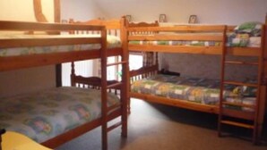 Une chambre avec un lit superposé en bois et un petit bureau.
