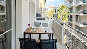 A balcony with a table set for two, chairs, and a view of the cityscape. - Beautiful 2-BR flat + terraces - Cannes centre - 7CV3 (Cannes)